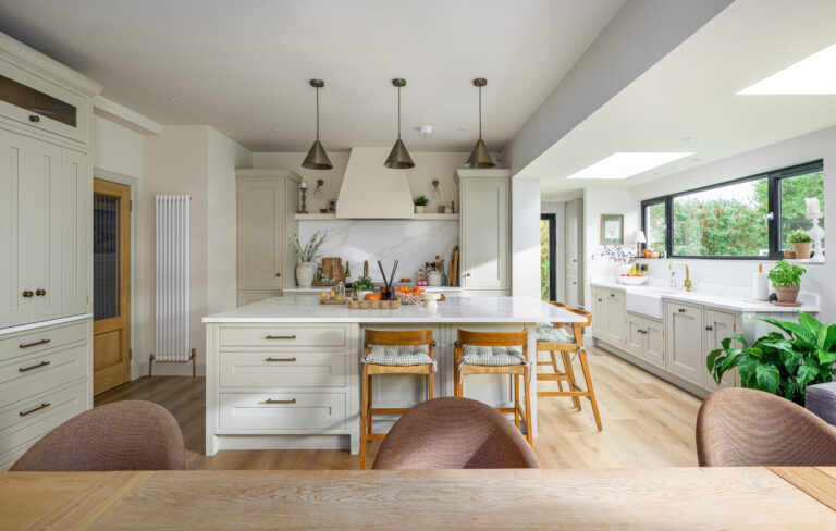 Beautifully photographed Shaker-style kitchen with soft green cabinetry, marble surfaces and warm natural light — timeless design by Mascari Design.